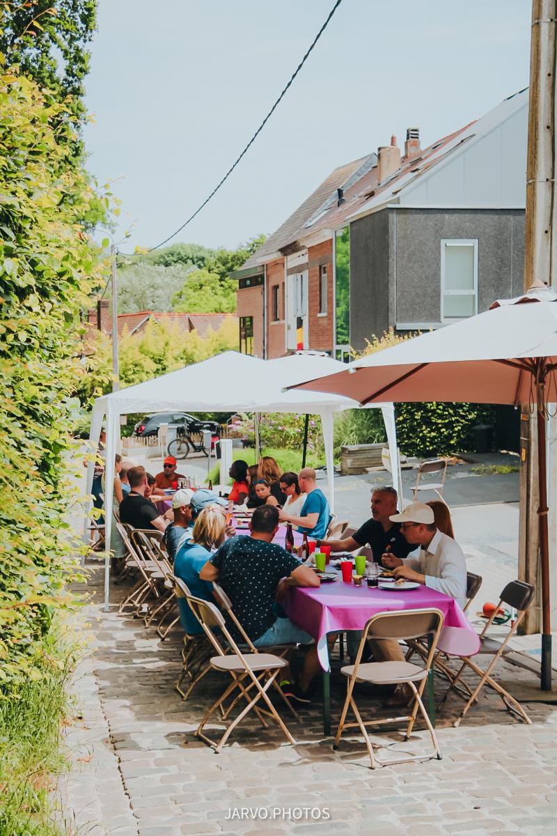 sfeerfoto van mensen aan lange tafel op straat