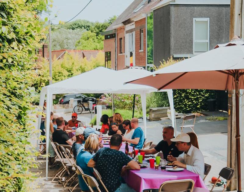 sfeerfoto van mensen aan lange tafel op straat